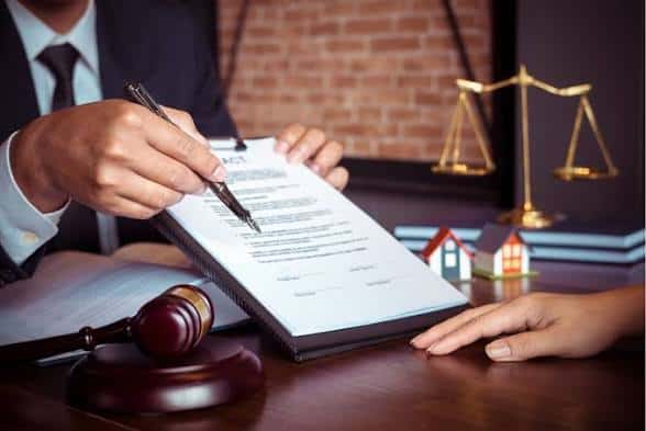 Pengacara menandatangani dokumen hukum di kantor pengadilan.